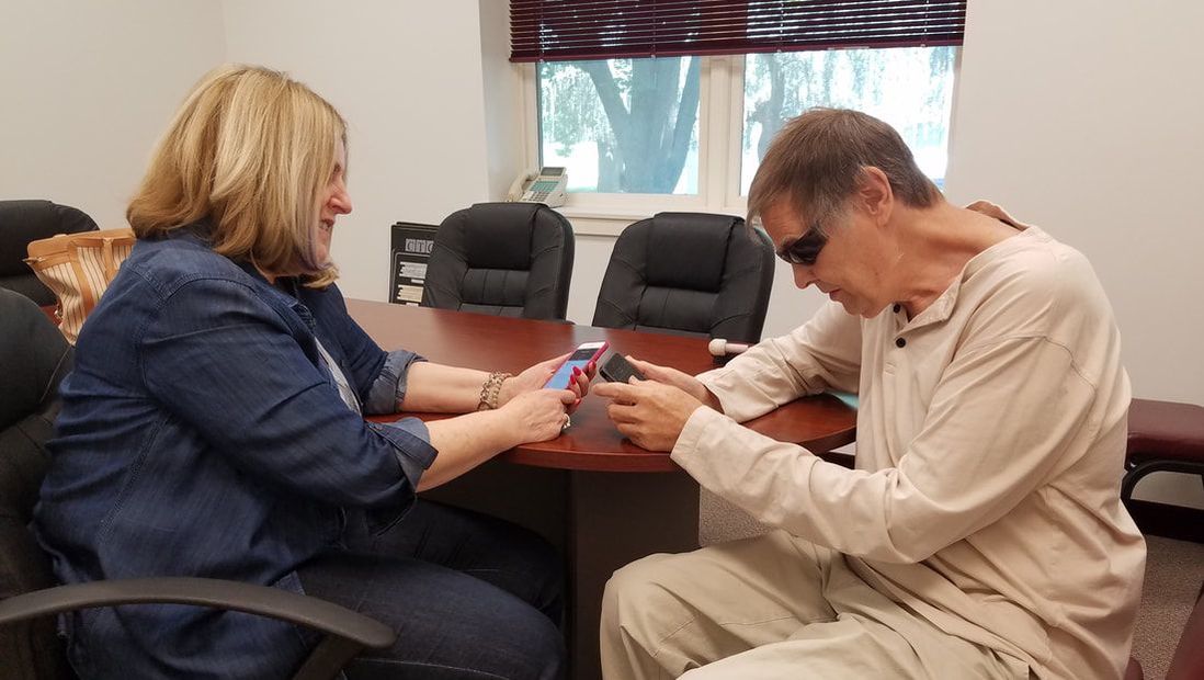 Picture of a client teaching another client about the iPhone